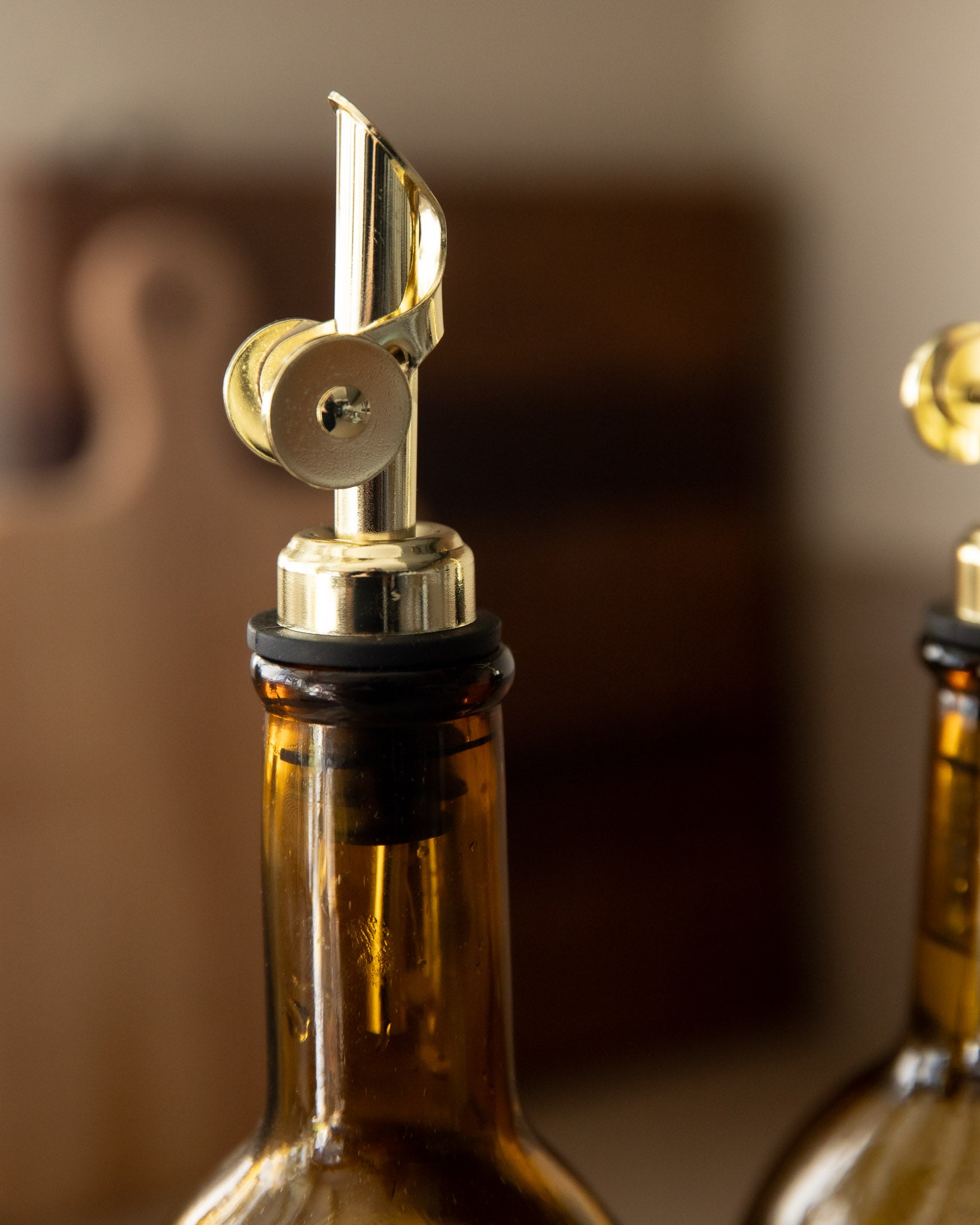 Close-up of a bottle pourer with a gold design on a blurred background