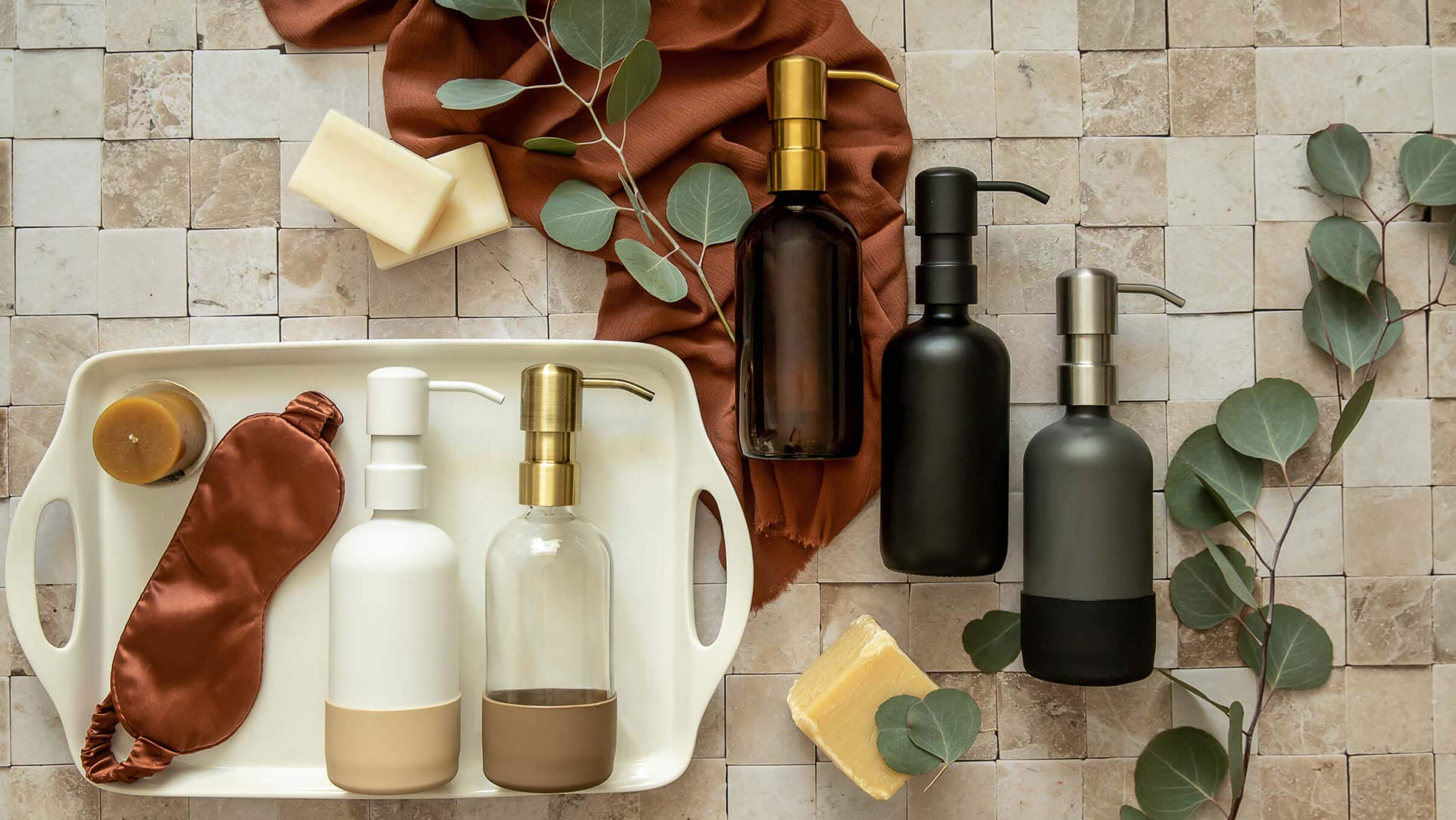 Soap dispensers, branches, and a serving tray lying on a neutral tile floor.