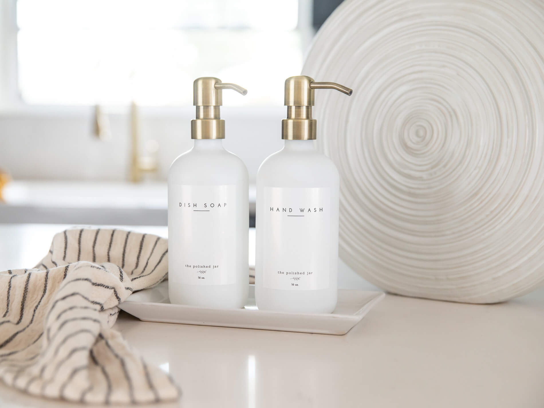 Two bottles of 'Fish Soap' and 'Hand Wash' on a tray with a neutral background.