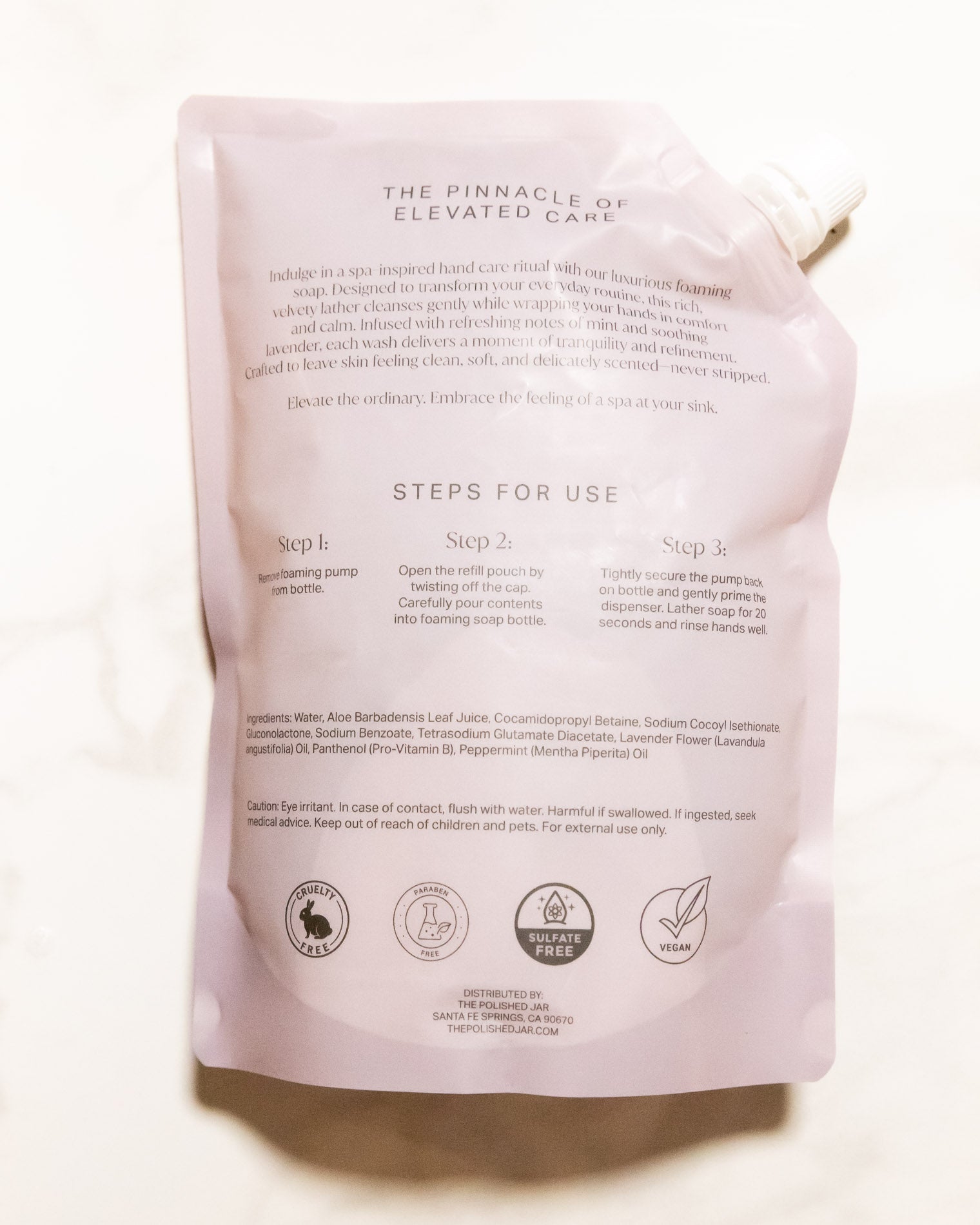 Back of a soap packaging with text and icons on a white background