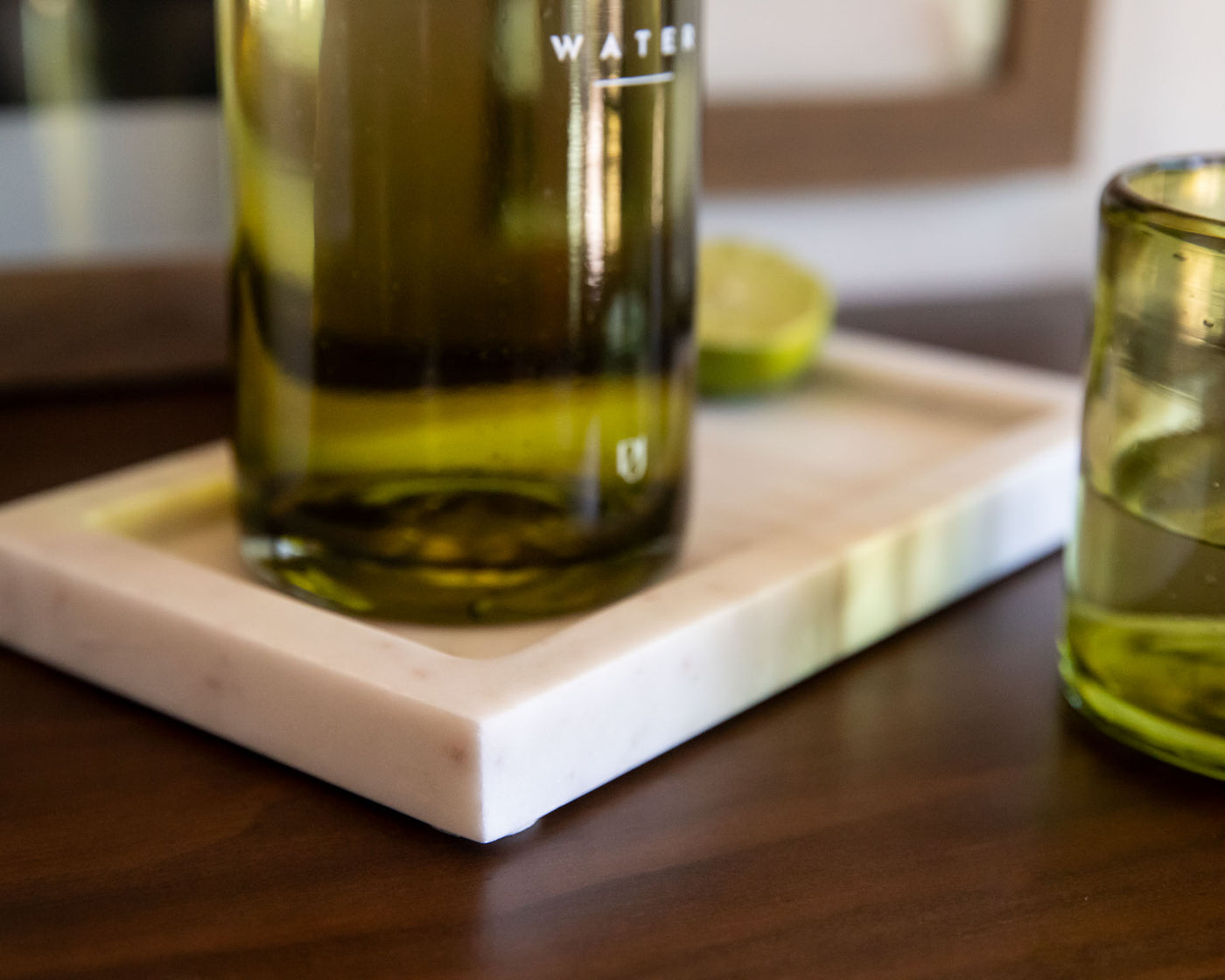 Two bottles of olive oil on a wooden surface with a blurred background