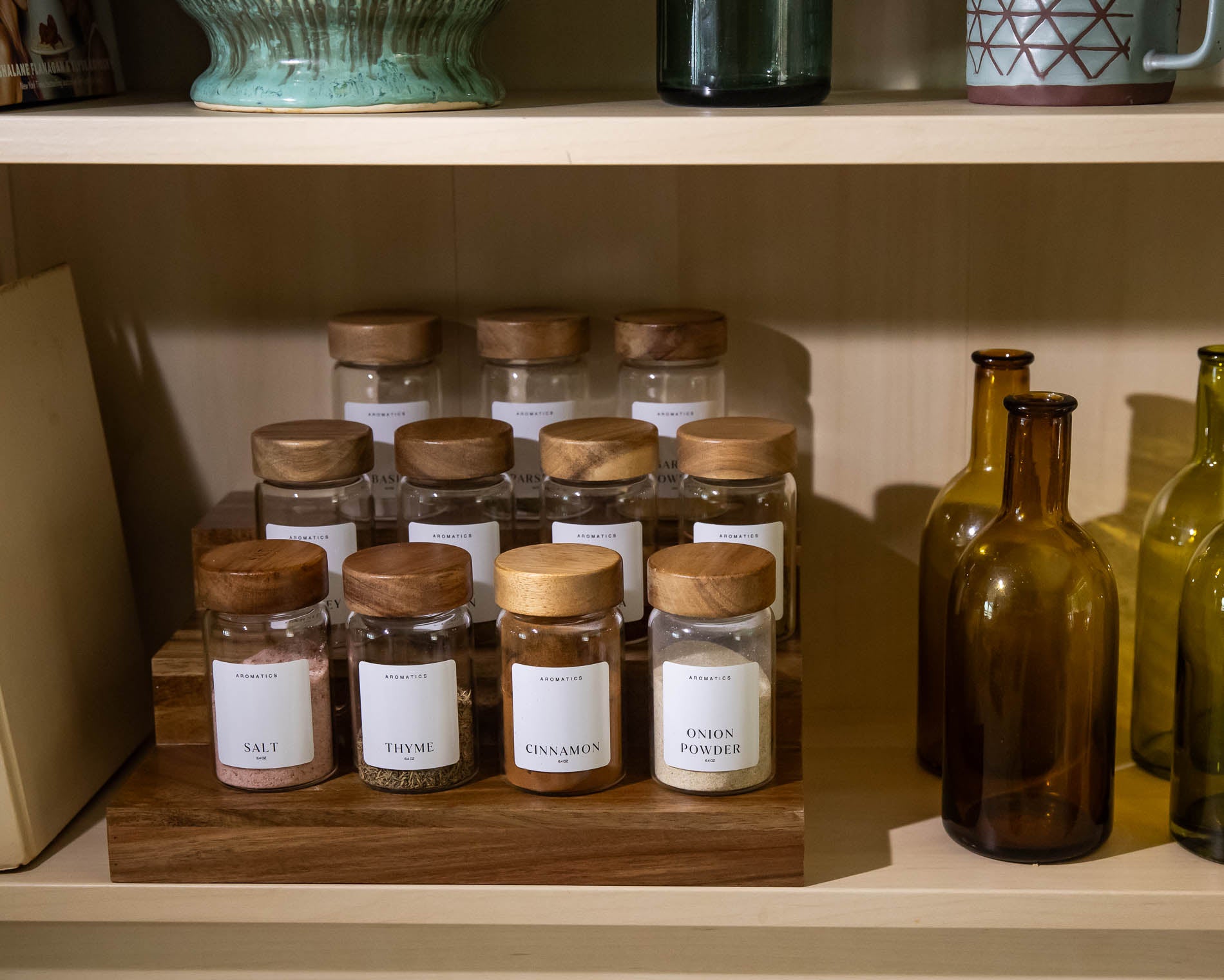 Waldorf Jars with wooden lids on a Acacia shelf with other bottles and containers.